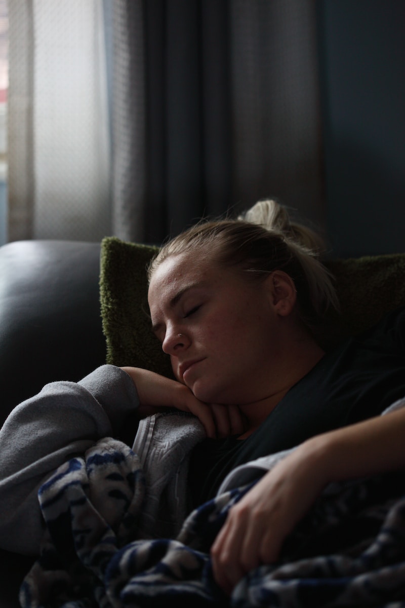 woman in black shirt lying on couch